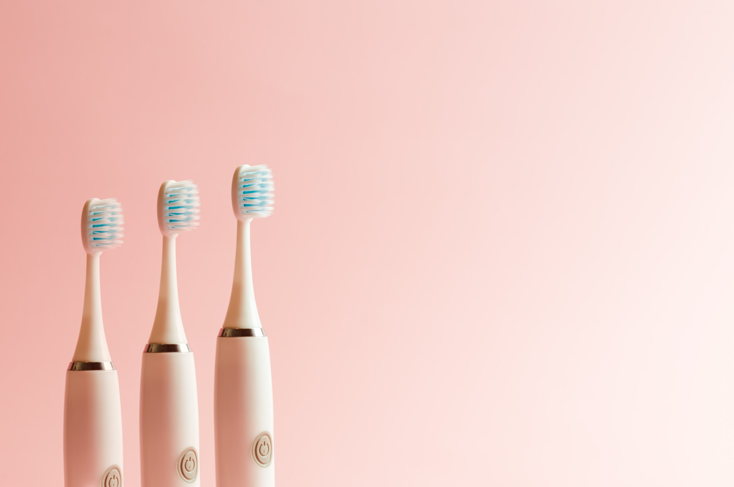 Conceptual shot of electrical toothbrush over a pink pastel background with copy space great dental customer service
